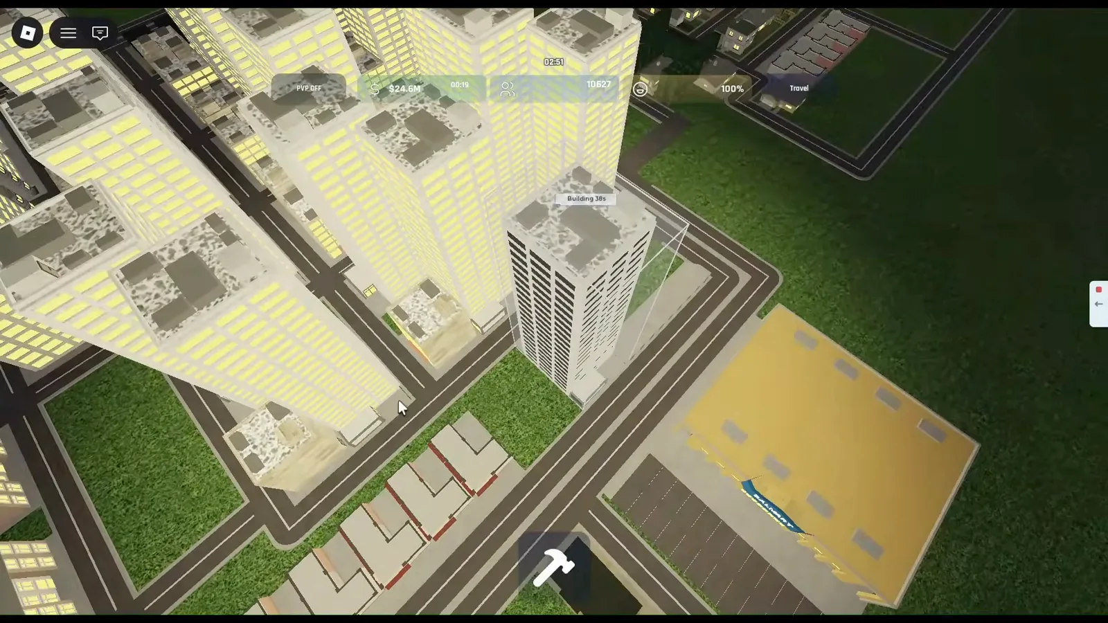 Build and Conquer Roblox overhead night view of a yellow-roof Walmart-style commercial building with a parking lot, suburban houses, paved roads, and lit apartment towers behind.